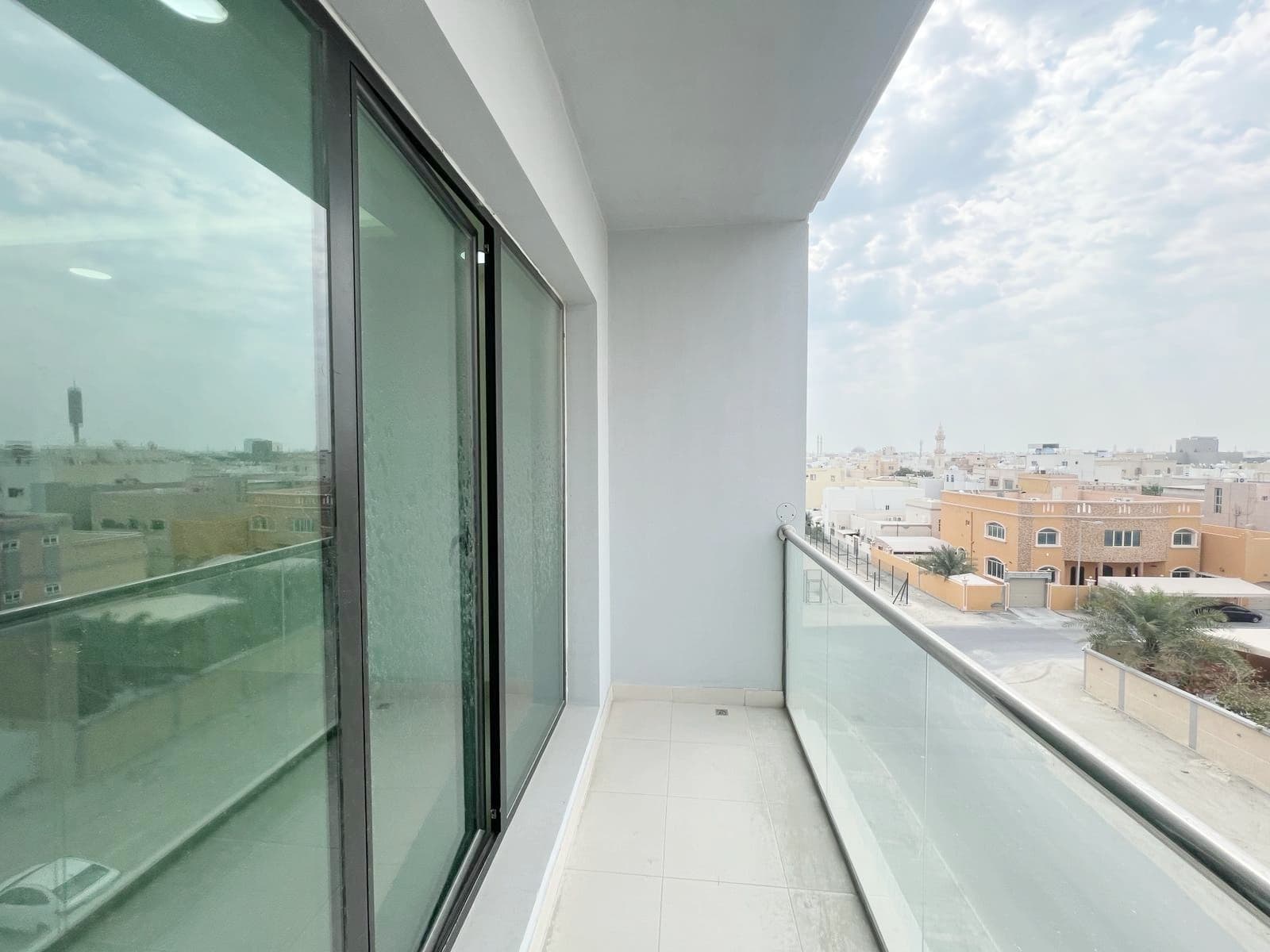 Balcony view from a high-rise apartment overlooking a cityscape on a cloudy day, captured in an Auto Draft.