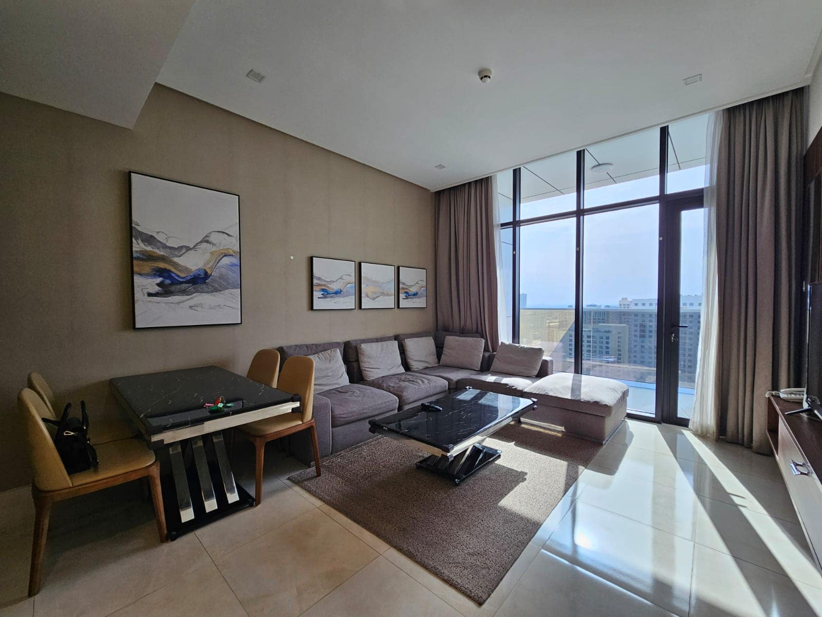 Modern living room with a sectional sofa, wall art, and city view. Auto Draft