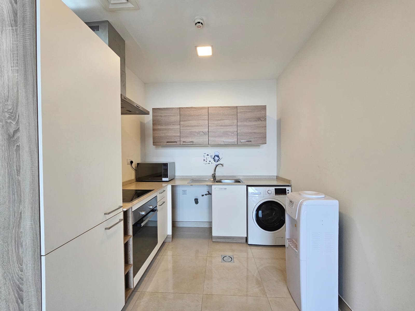 A modern laundry room with auto draft washer, dryer, and kitchenette.