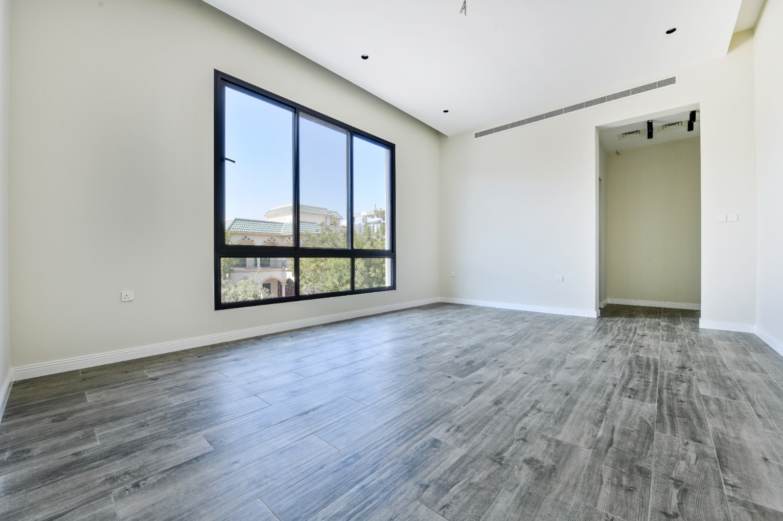 Auto Draft: Empty room with large window, gray flooring, and Auto Draft.