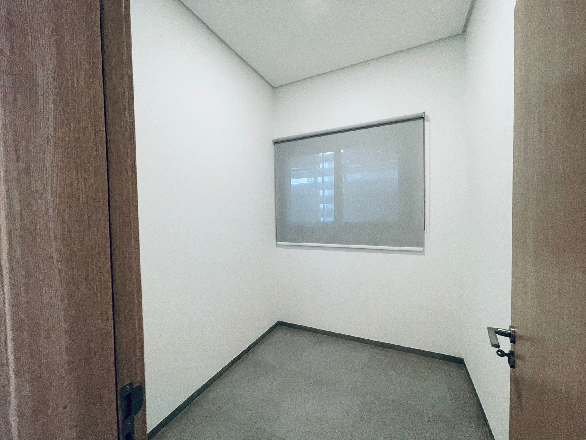 Small empty room with an auto draft, an open door, and a frosted glass window.