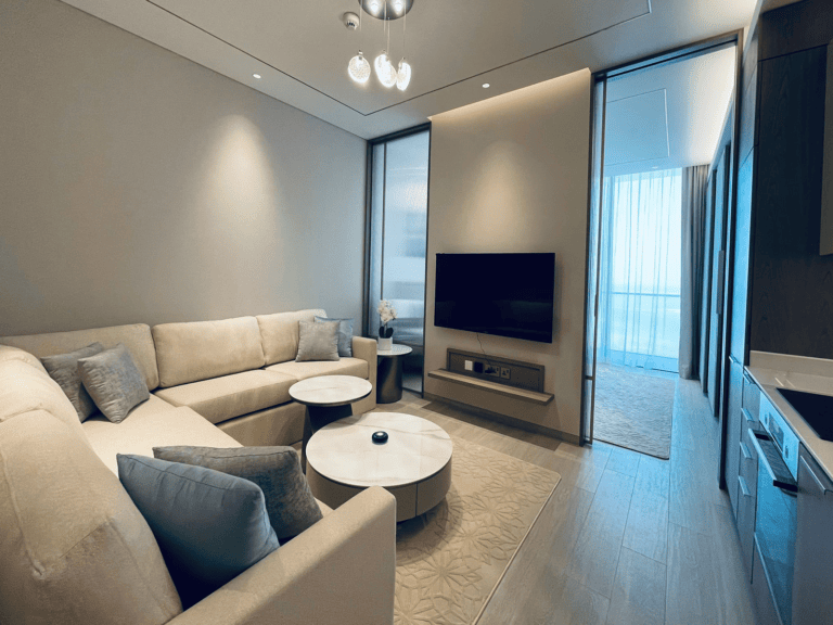 Modern living room in an amazing apartment with a sectional sofa, television, and minimalist decor.