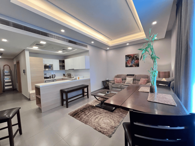 Luxury flat interior featuring an open-plan living room with kitchen, dining area, and lounge, decorated in neutral tones with accent lighting.