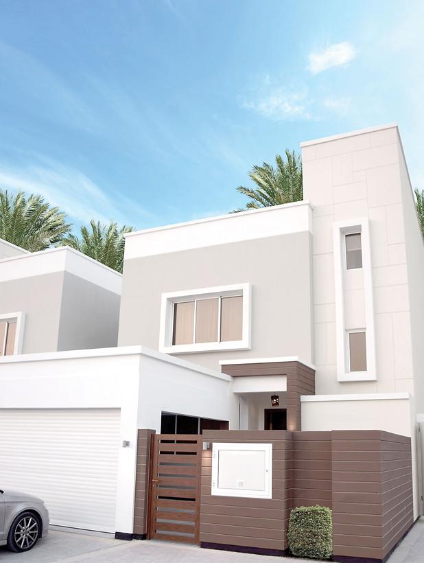 Modern two-story villa in Diyar Al Muharraq with flat roof design, featuring a garage and a wooden front gate, situated under clear skies with palm trees nearby.