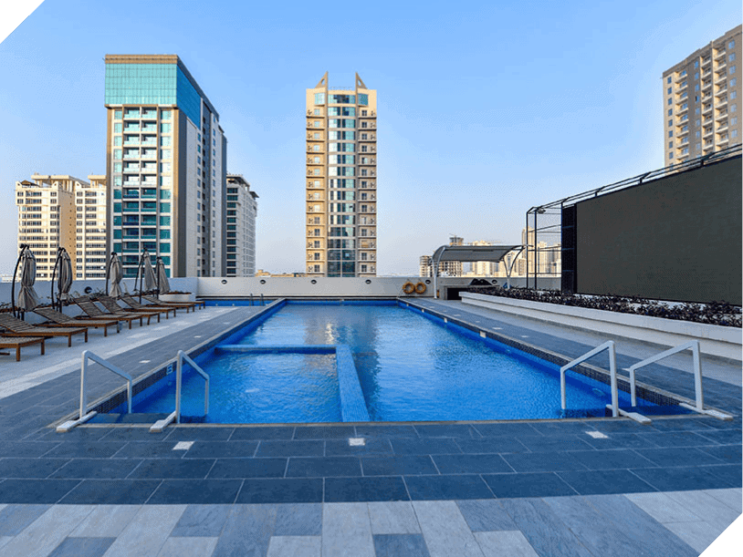 Perched atop, our rooftop swimming pool with its striking blue tiles is a tranquil oasis. Surrounded by cozy lounge chairs and offering breathtaking views of Bahrain's skyscrapers, it invites you to bask in luxury. Let this serene escape house you above the vibrant city below.