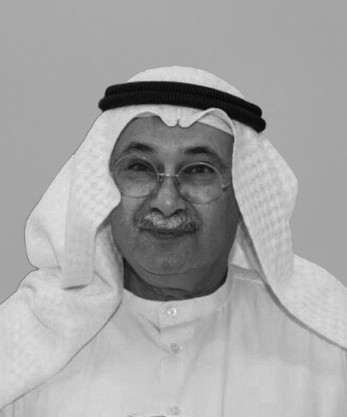 An older man, wearing glasses and a white robe accompanied by a traditional Arab headdress, smiles warmly against a plain background—his demeanor reflecting the trust and expertise synonymous with House Me Bahrain company in providing premier commercial real estate services.