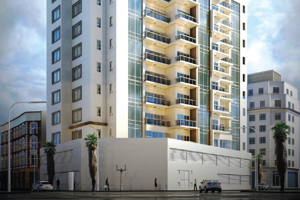 A modern multi-story apartment building with balconies and large windows, located on a city street with cars and pedestrians nearby.