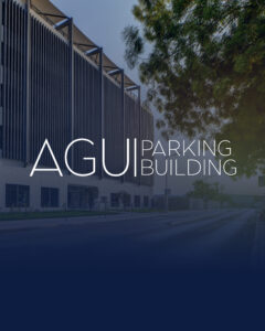 Exterior view of the AGU Parking Building showcasing modern architecture, large windows, and a tree on the right side. The AGU Parking facility stands out for its contemporary design and attention to detail.