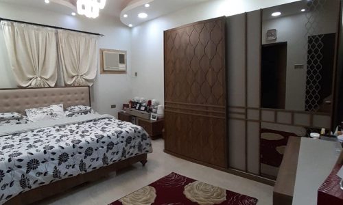 Apartment for sale in Samaheej with a bed and a mirror.