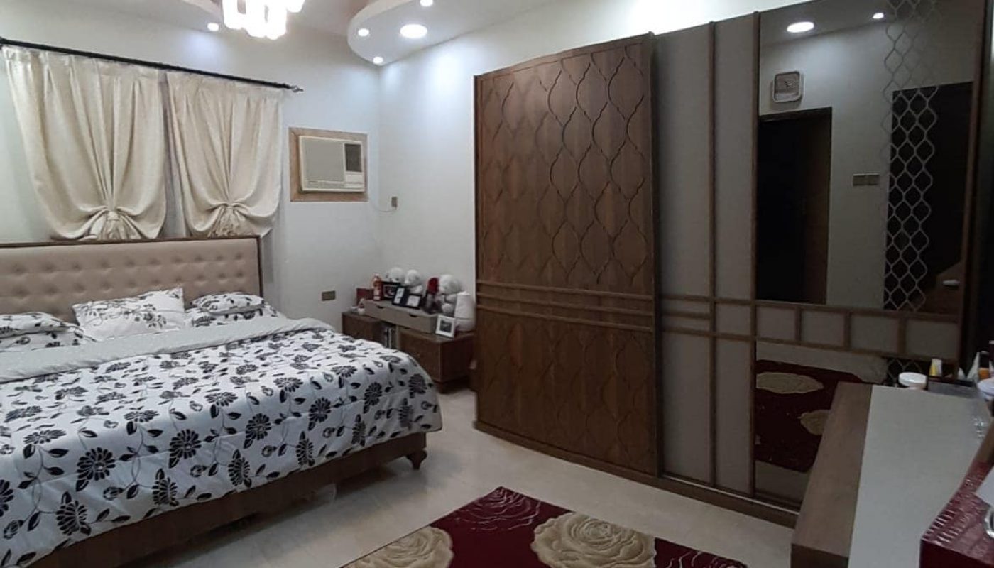Apartment for sale in Samaheej with a bed and a mirror.