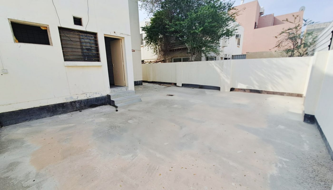 A small backyard with a concrete floor and a fence is available for sale in Hamad Town.
