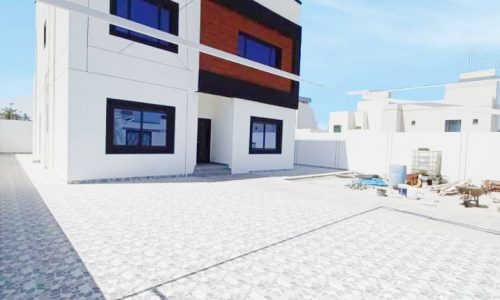 A brand new 3BR villa for sale with a white house and a white tiled driveway.