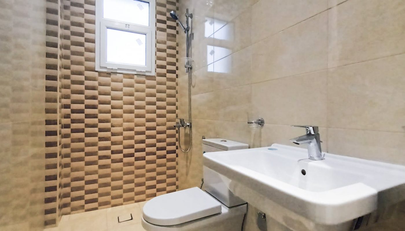 Newly tiled bathroom with toilet.