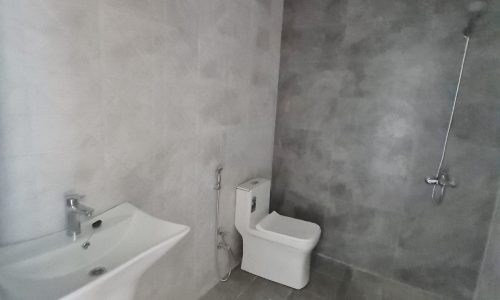 A bathroom in a stunning new villa for sale in Malkiyah, featuring a toilet and sink.