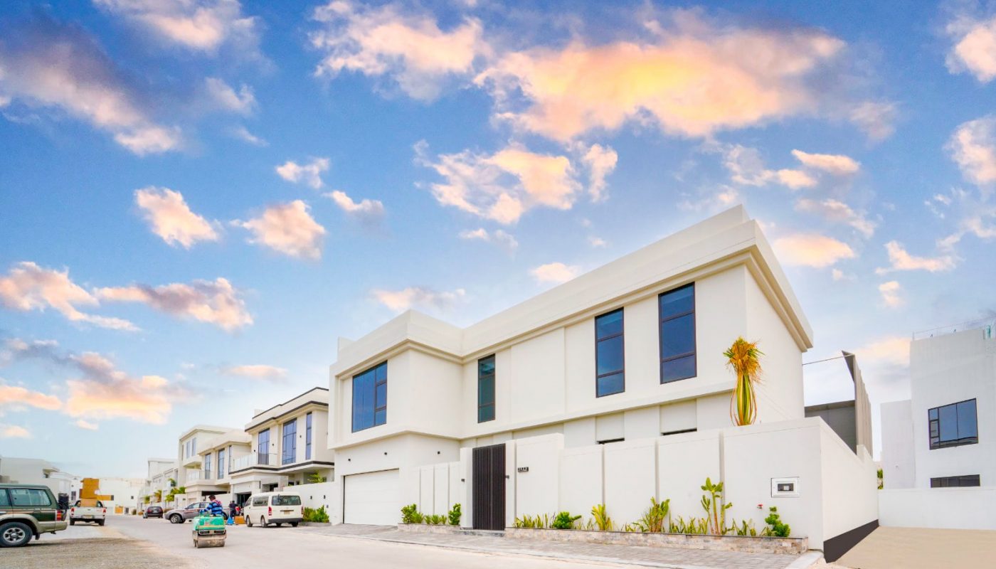 A luxurious 5BR Villa in Saar with cars parked in front of it.