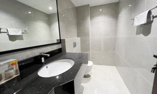 A black and white bathroom with sink in a 3BR Fancy Apartment for Sale in Amwaj Islands.