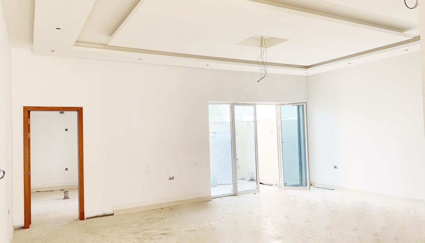 An empty room with white walls and a door in an ideal location for sale.