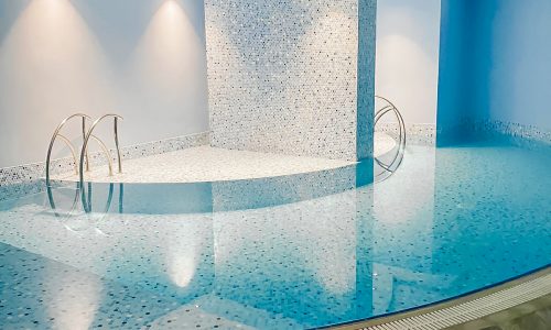 A bright indoor swimming pool in a hotel.