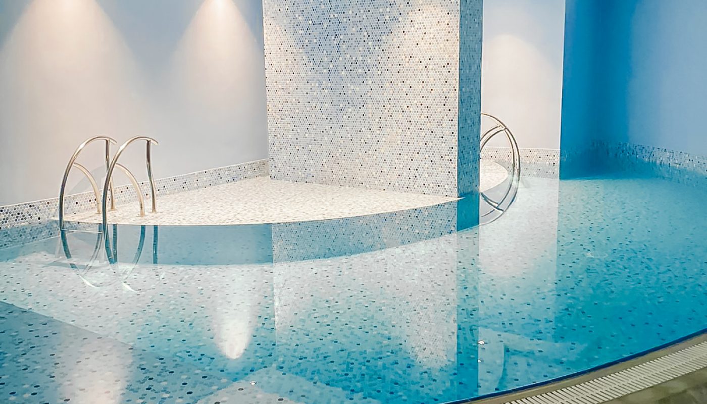 A bright indoor swimming pool in a hotel.