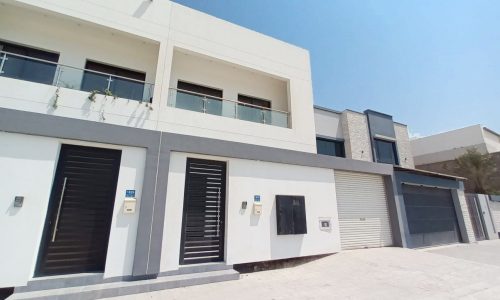 A modern villa for sale in Hamad Town with a garden.