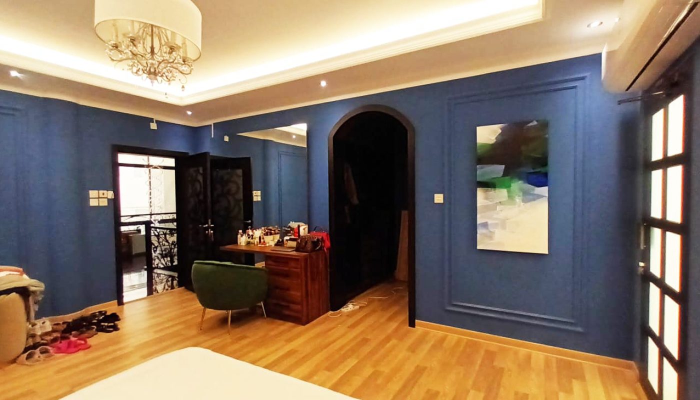 An amazing bedroom with blue walls and a chandelier.