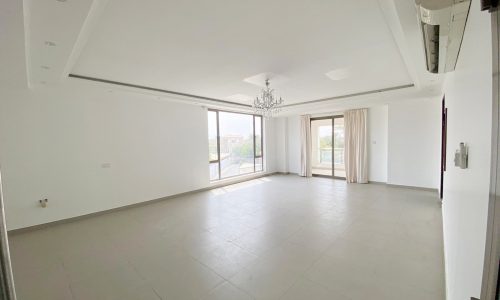 An empty living room with a sliding glass door.