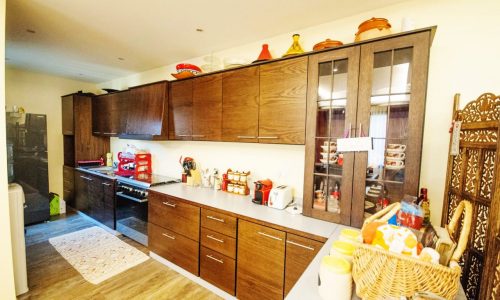 Keywords used: kitchen, wooden cabinets, refrigerator

Modified description: A spacious kitchen furnished with beautiful wooden cabinets and equipped with a modern refrigerator.