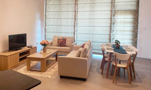 An apartment in Seef with a dining table and chairs for sale.