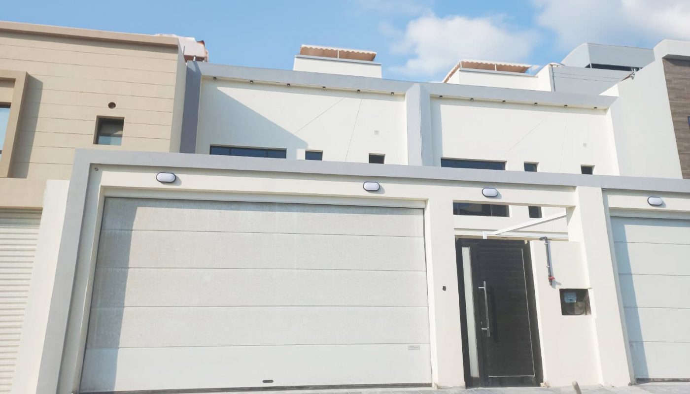 A distinguished villa in Malkiya with two garages and a blue sky.
