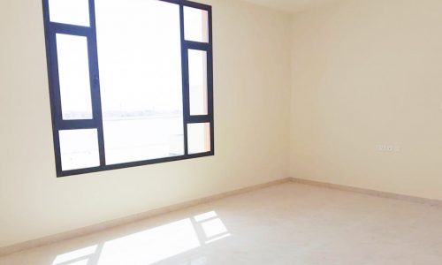 An empty room with a modern window and tile floor.