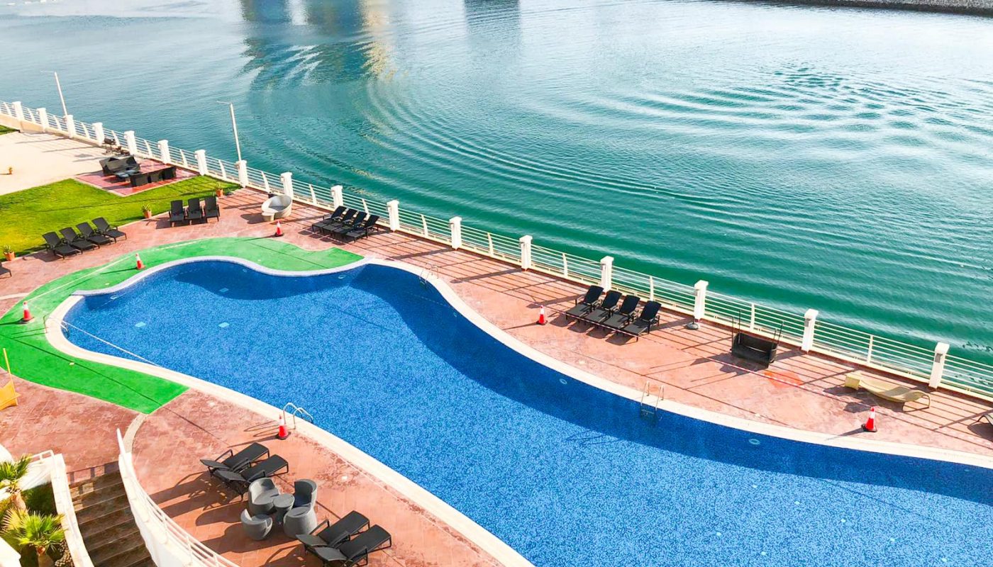 An aerial view of a luxurious swimming pool next to the sea.