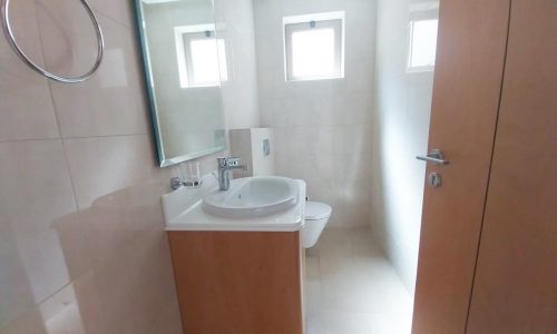 A cozy bathroom with a toilet and sink, located in a 2BR apartment for rent in Diyar Al Muharraq.