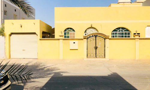 Spacious yellow house with a car parked in front of it in a prime location.