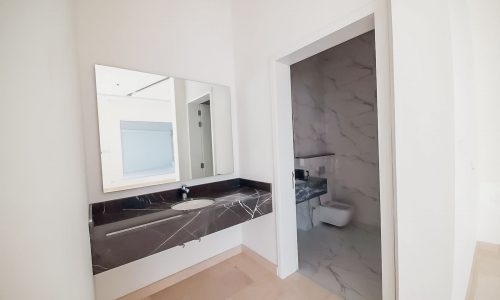 A luxurious bathroom with marble counter tops and a mirror.