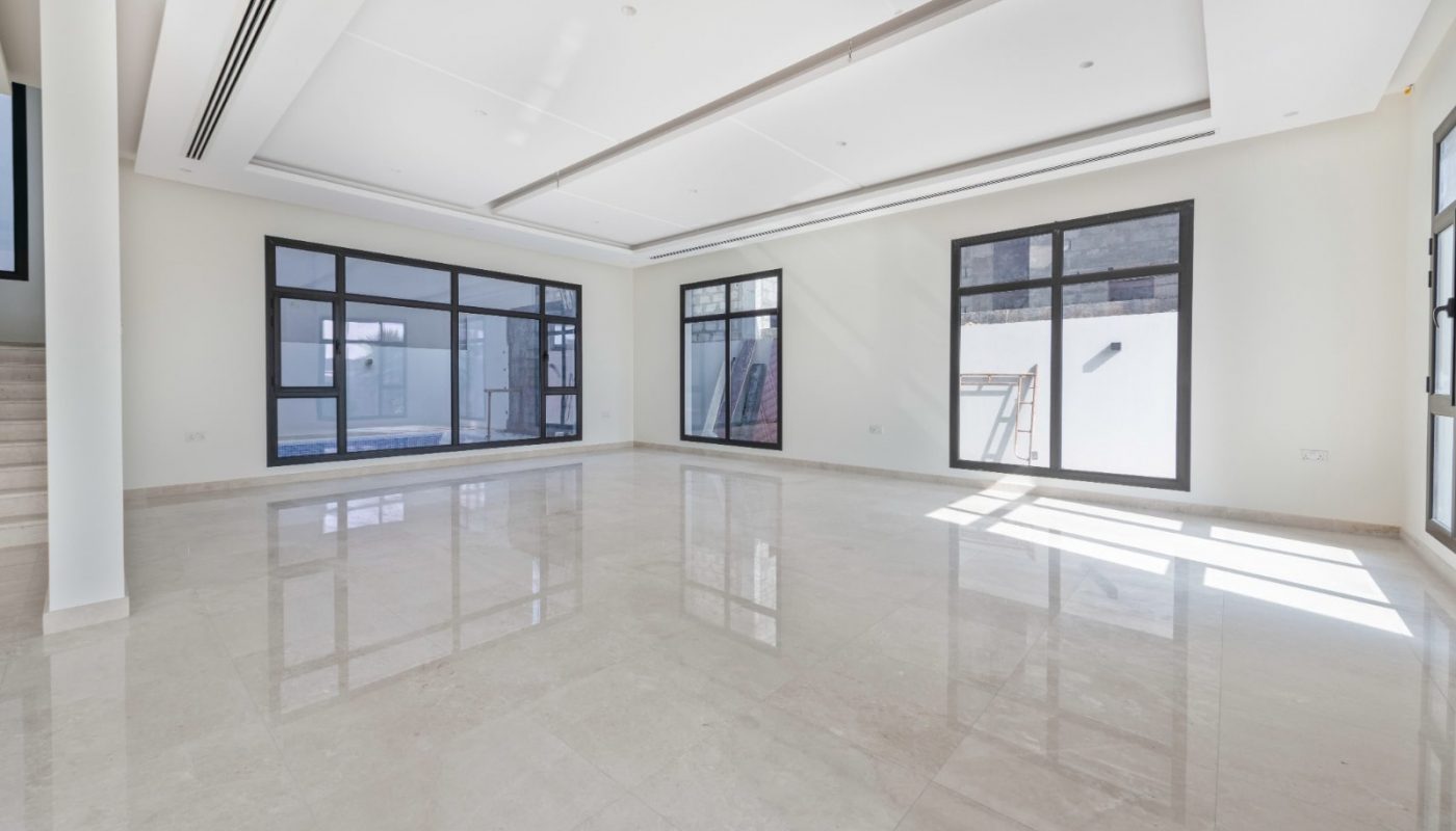 Spacious, empty room with polished marble floor, large windows, and minimalist design featuring recessed ceiling lighting and neutral tones.