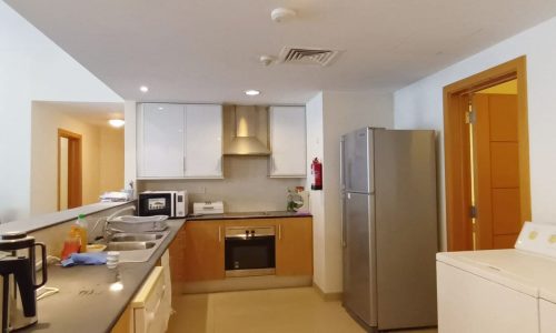 A modern apartment with a kitchen equipped with a washing machine and refrigerator.