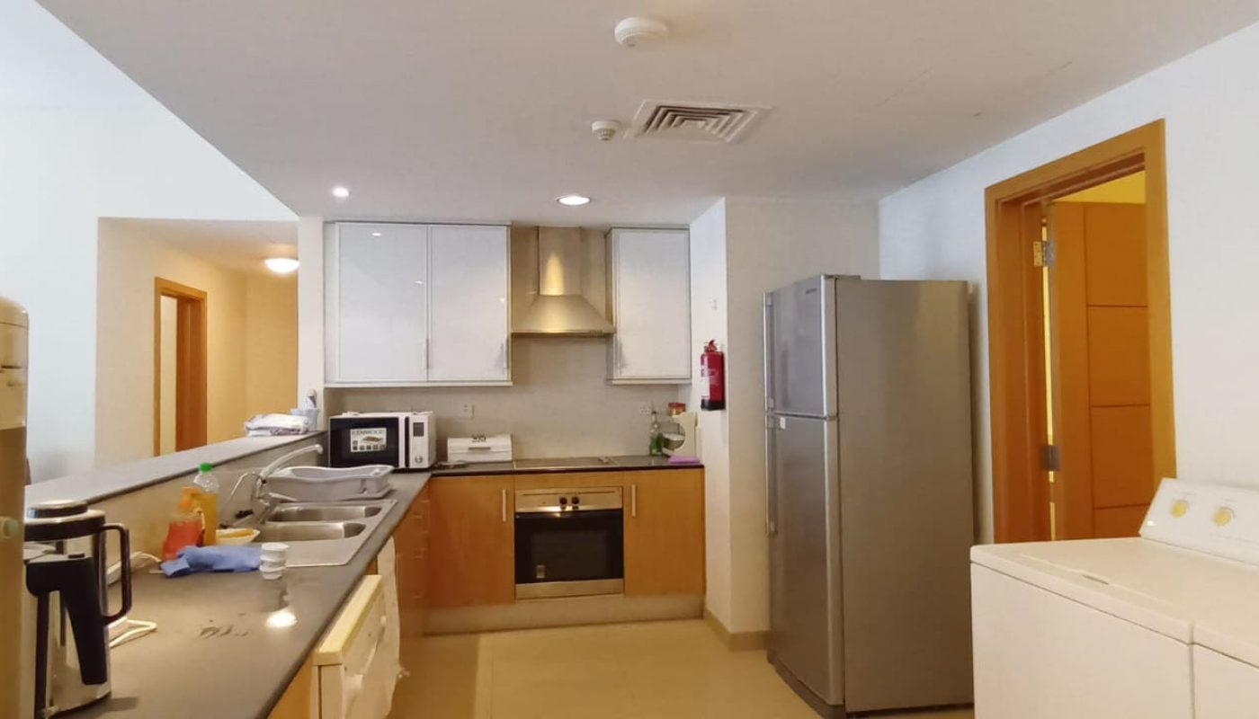 A modern apartment with a kitchen equipped with a washing machine and refrigerator.