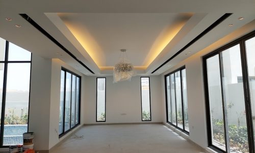 A Mesmerising living room with large windows and a chandelier in a Villa for Sale in Al Qurrayah.