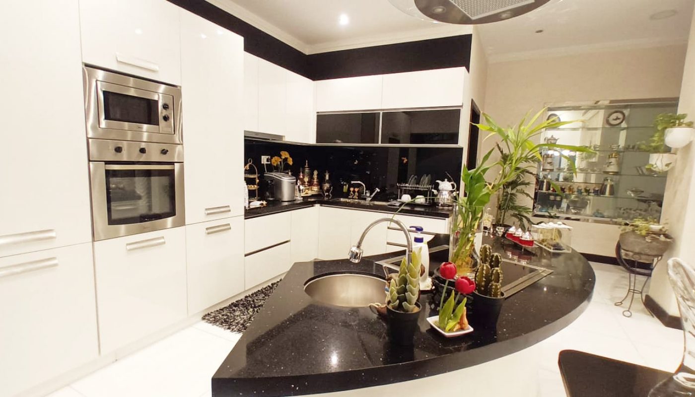 A black and white kitchen with a modern counter top.