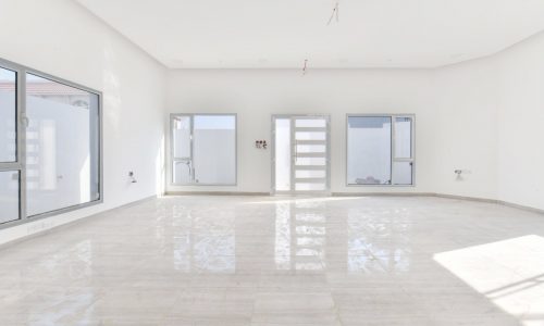 A brand new villa with large windows and white walls.