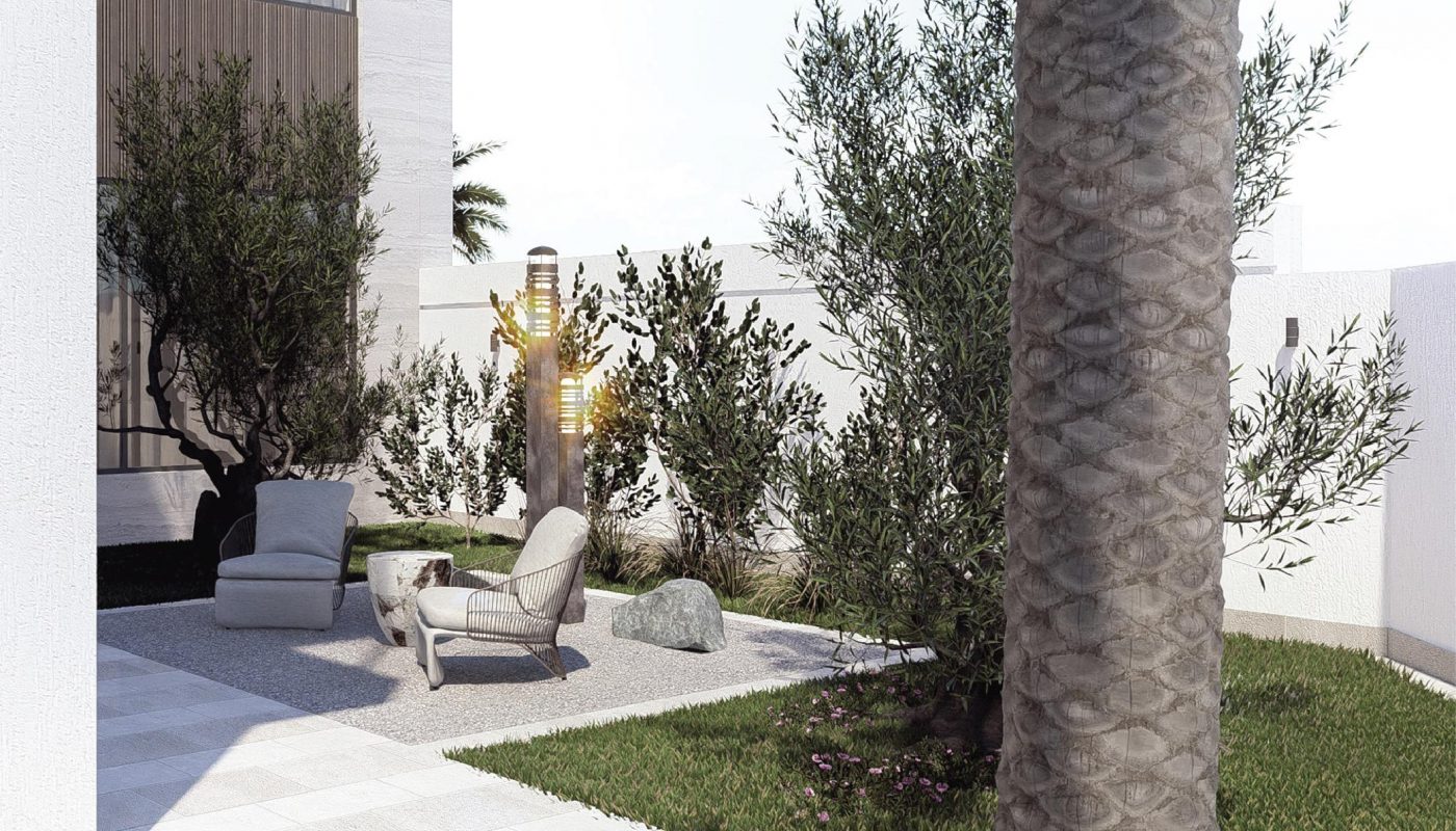 Modern outdoor patio with two lounge chairs, a sculpture, and trees, surrounded by a white fence and a mix of grass and paved areas.