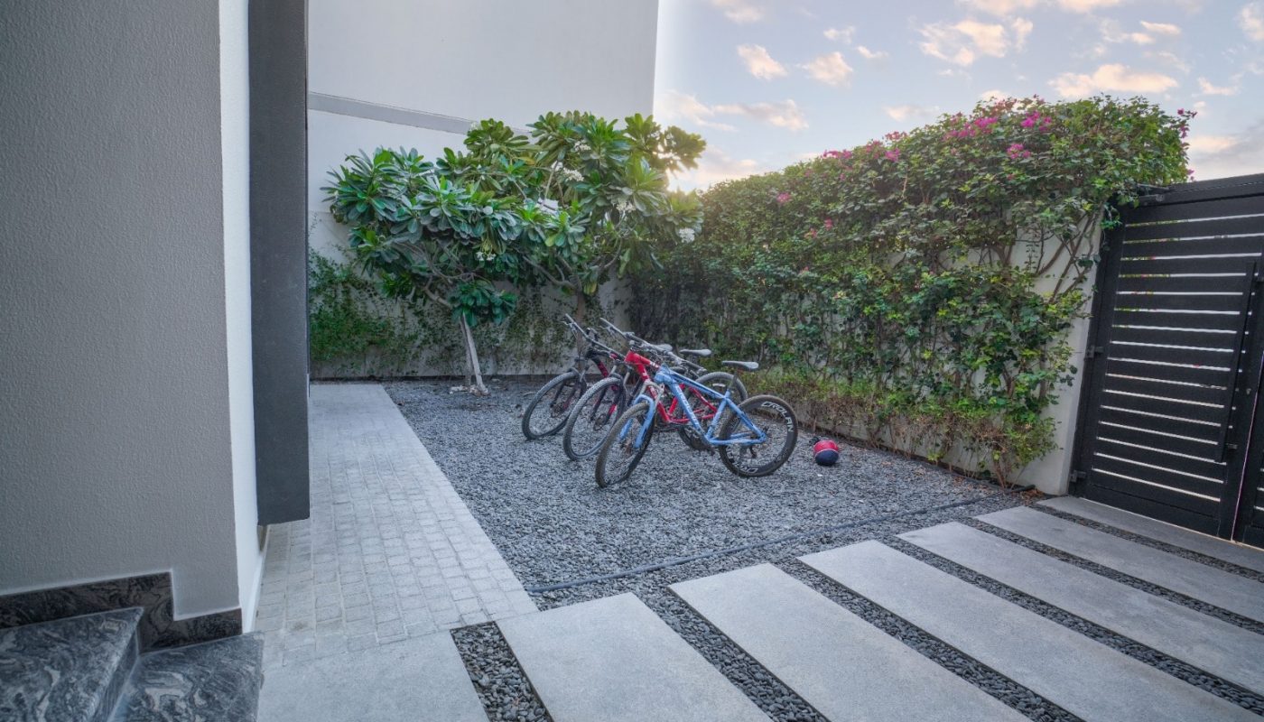 Two bicycles are parked in the driveway of an eye-catching villa.