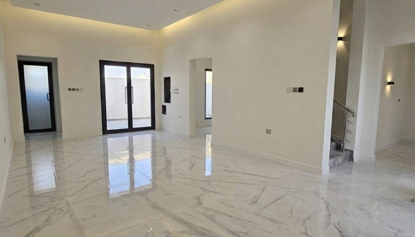 Spacious, modern living room with glossy marble floors, recessed lighting, large windows, and minimalistic white walls.