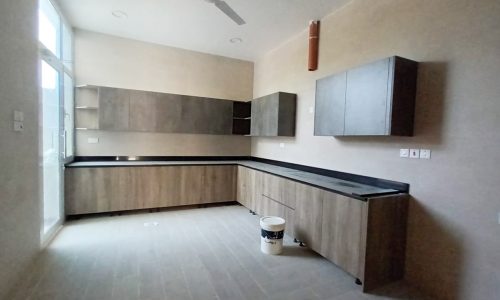 A 4BR villa for sale in Bani Jamra with wooden cabinets and a ceiling fan.