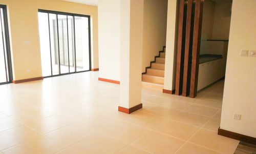 An empty living room with a sliding glass door in a stunning villa.