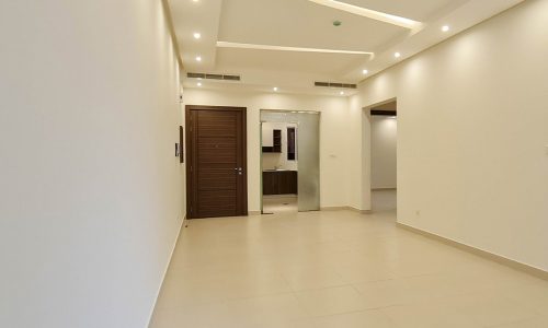 A white-walled hallway in a spacious new building.