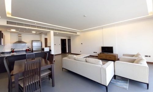 A modern apartment with a living room, kitchen, and dining area, available for rent in Reef Island with a lovely view.