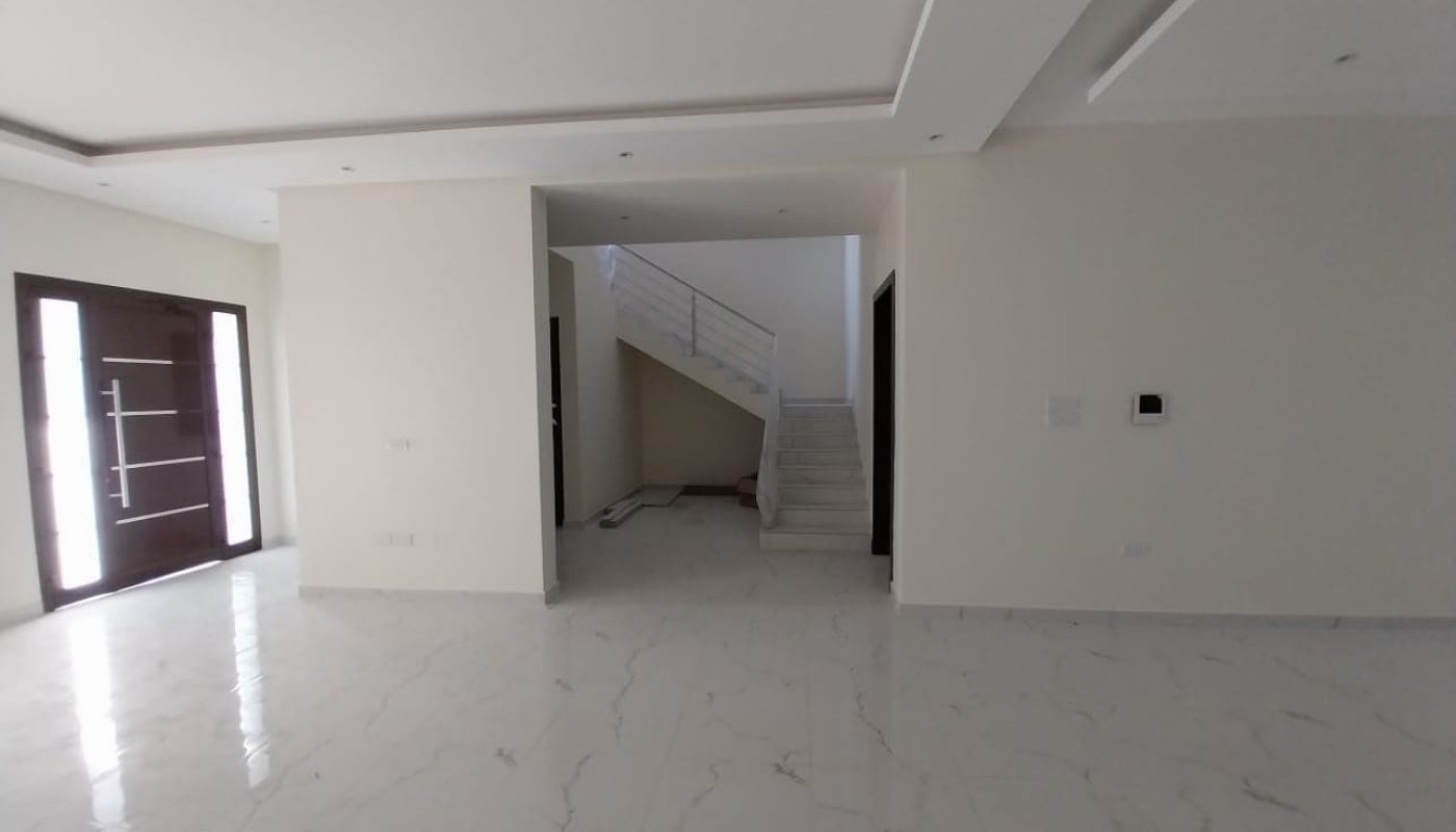 An Amazing Villa with a white tiled floor in a room with a staircase.