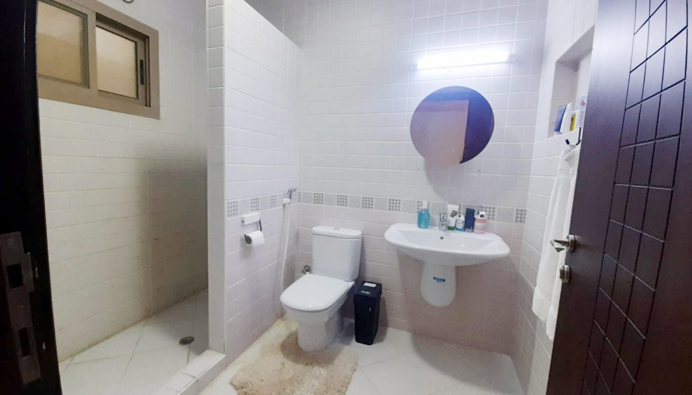 A bathroom with a toilet, sink, and mirror in an amazing 3BR flat for sale in Jabalat Habshi Area.