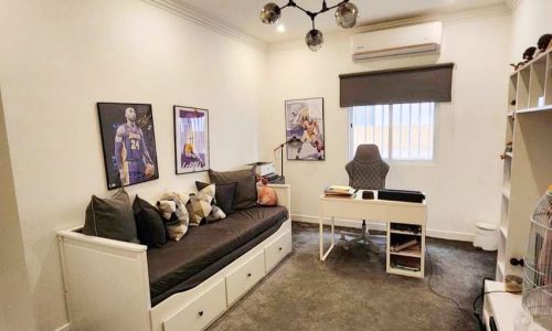 A luxurious apartment in Tubli with a bed, desk, and TV.